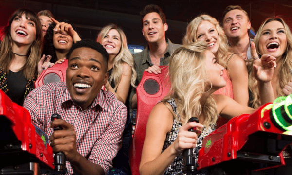 Group of friends excited playing arcade games together