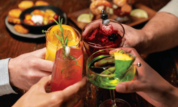 Colorful craft cocktails being toasted