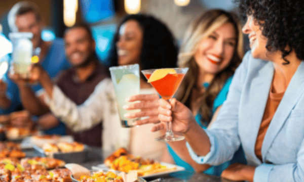 Friends enjoying cocktails and food at Outta Boundz