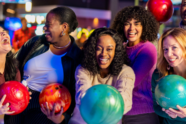 Friends celebrating at Outta Boundz with bowling balls