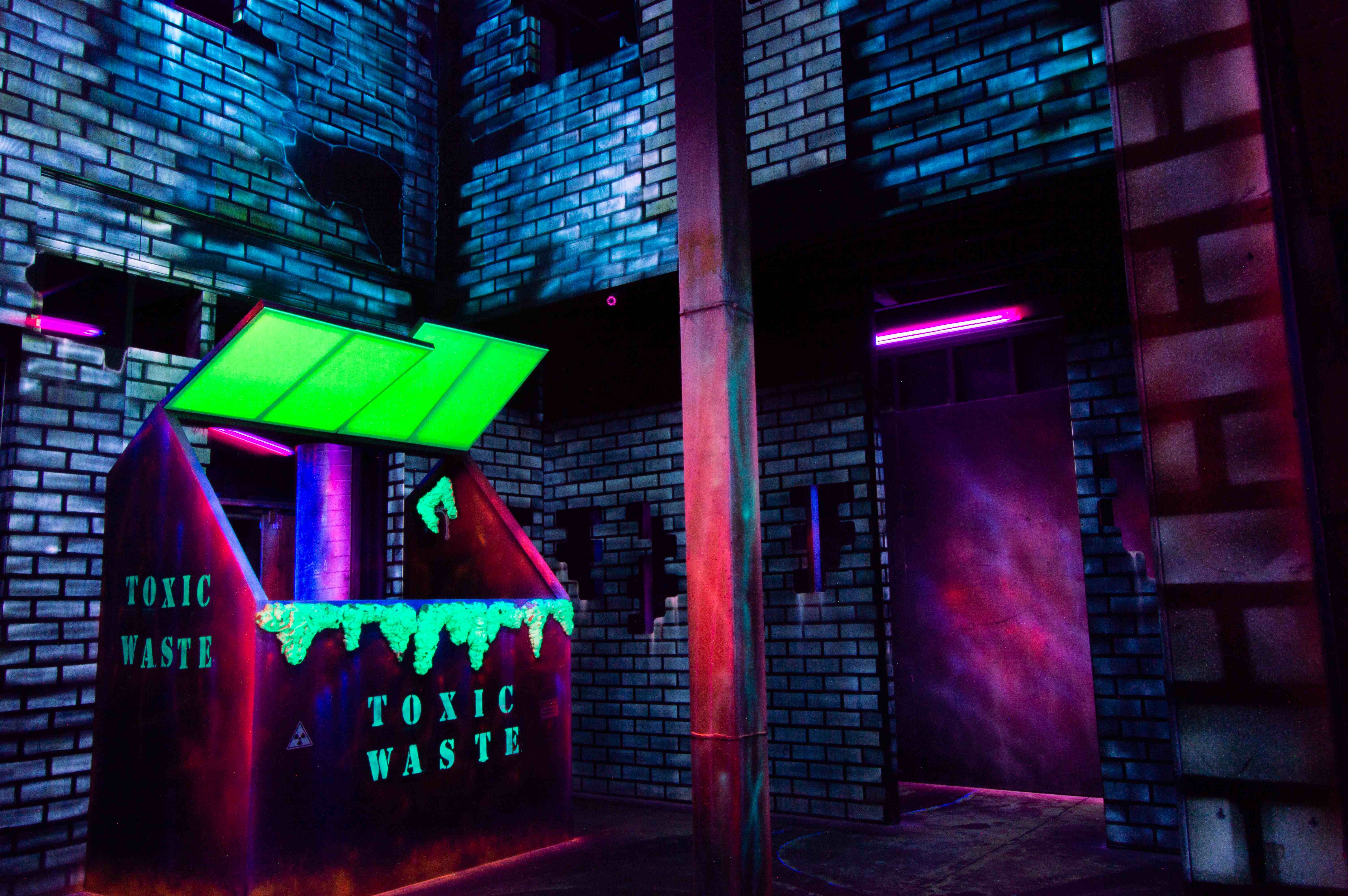 Laser tag arena with neon lighting and obstacles